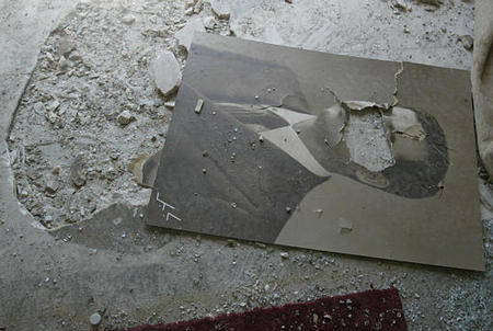 A torn photo of President Saddam Hussein lays on what used to be a mosaic of the face of former President Bush at the entrance of Ar-Rashid Hotel, after it was looted, Baghdad, April 11, 2003.